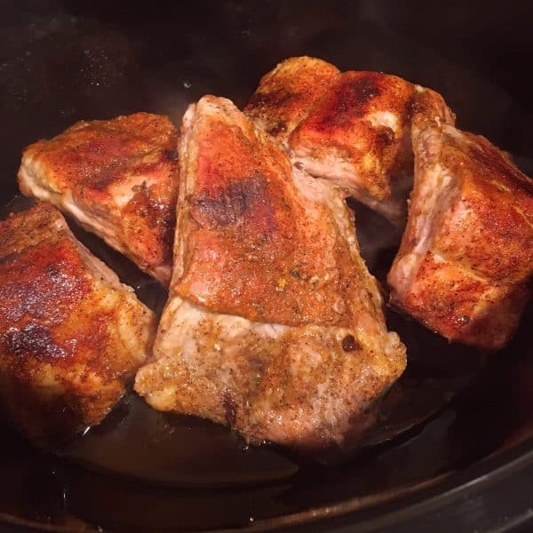 Layering baked spiced rubbed ribs in slow cooker
