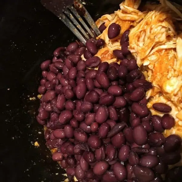 Adding rinsed black beans with shredded taco chicken