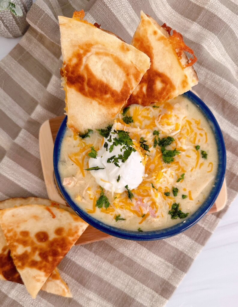 Chicken Enchilada soup with a golden crispy cheese quesadilla in a soup bowl.