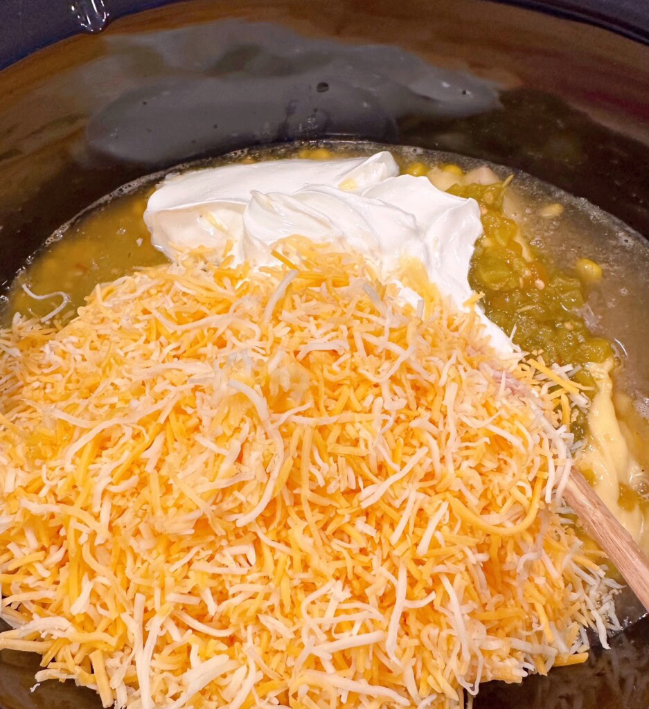 Adding Sour cream and cheese to enchilada soup.