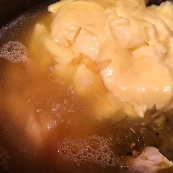 Slow cooker with chicken cream soup with chicken broth and seasonings