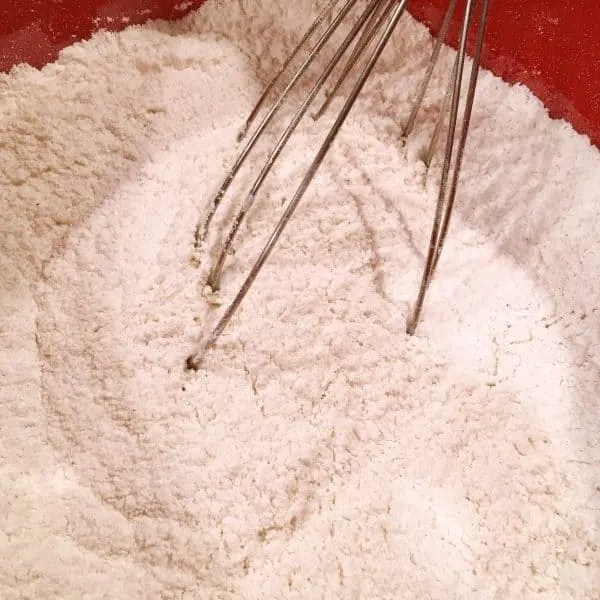 Whisking flour and spices together in a bowl