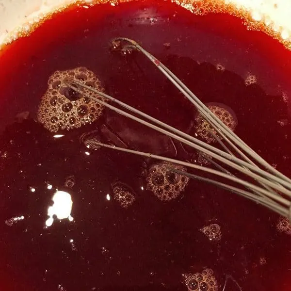 whisking together cranberry sauce and orange jello