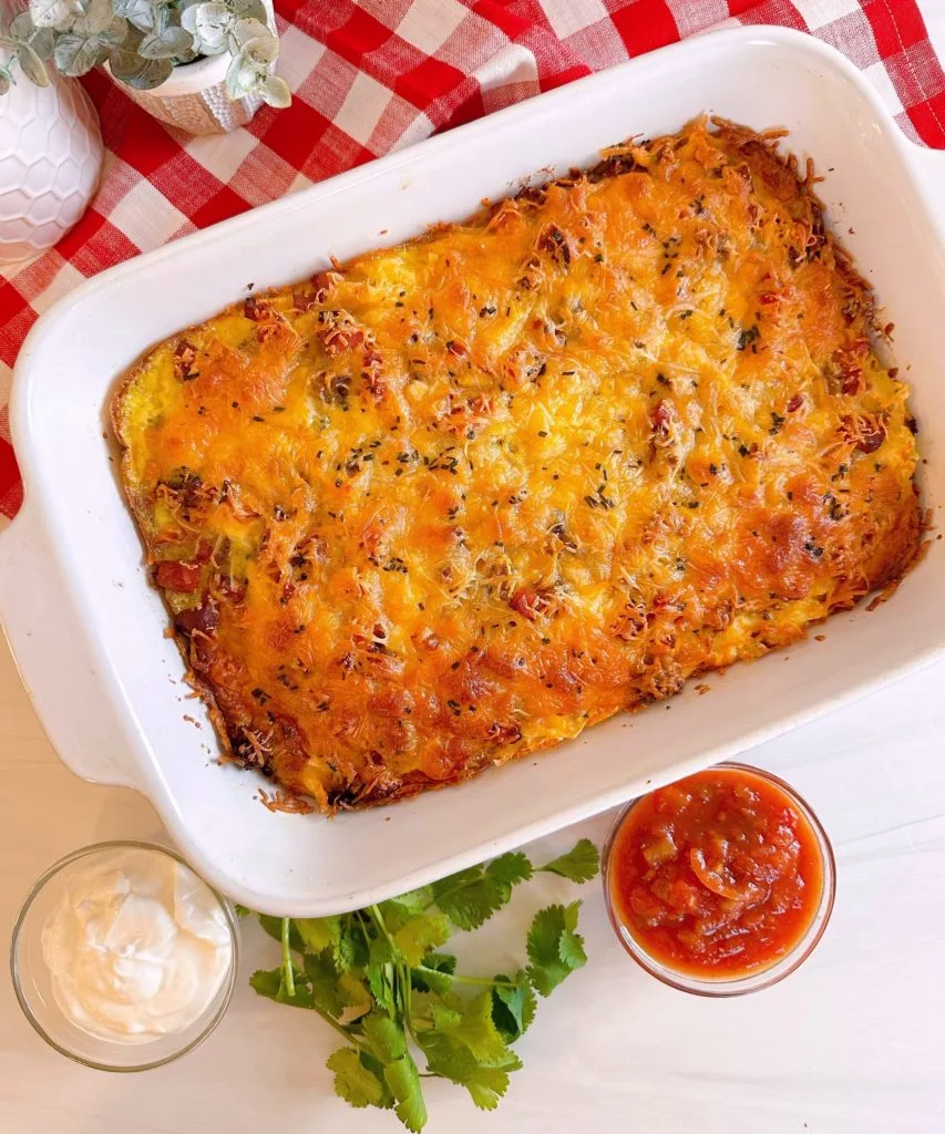 Cooked Casserole on a red and white checker cloth surrounded by toppings.
