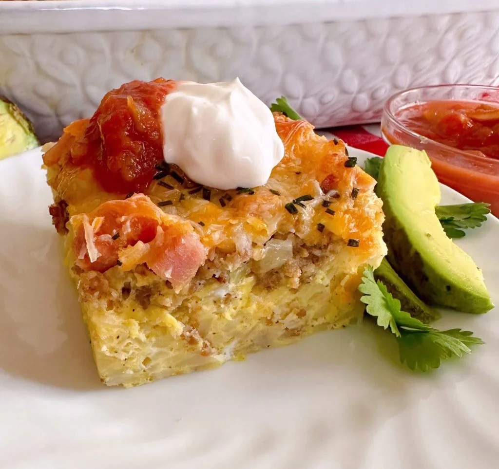 Breakfast casserole on a plate with toppings.