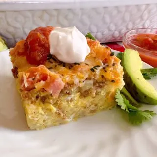 Breakfast casserole on a plate with toppings.