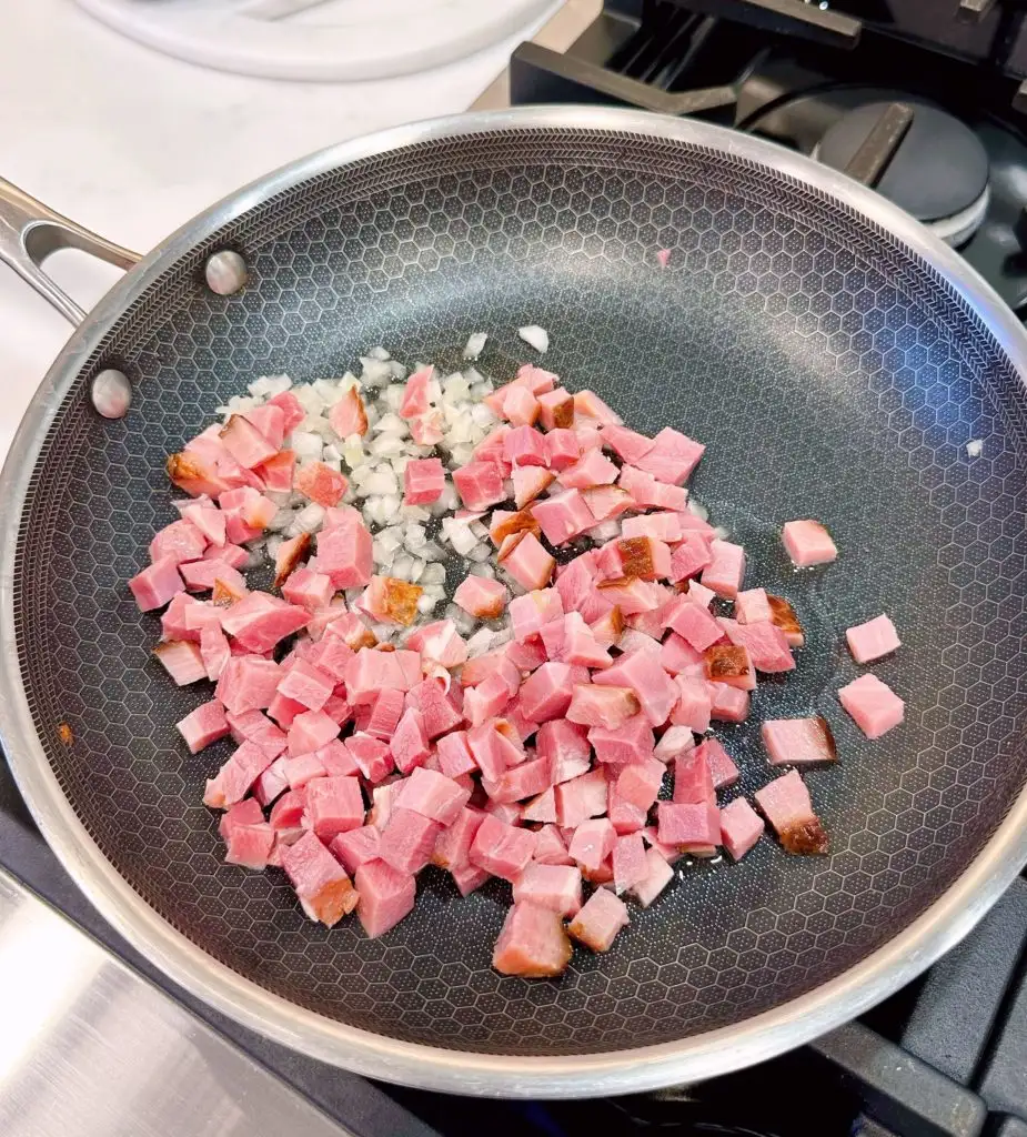 Saute onions and ham in a large skillet on the stove top.
