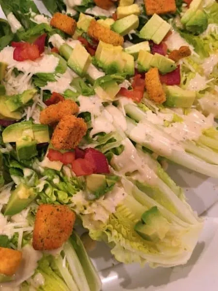 Romaine Lettuce heads cut in half and topped with avocado, cheese, and dressing