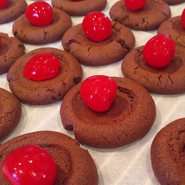 Placing cherry on top of chocolate cookie