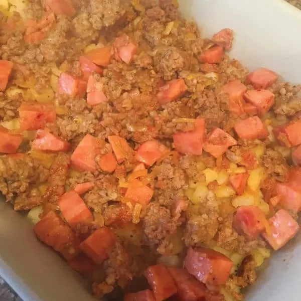 Hashbrowns, sausage, and ham in casserole dish