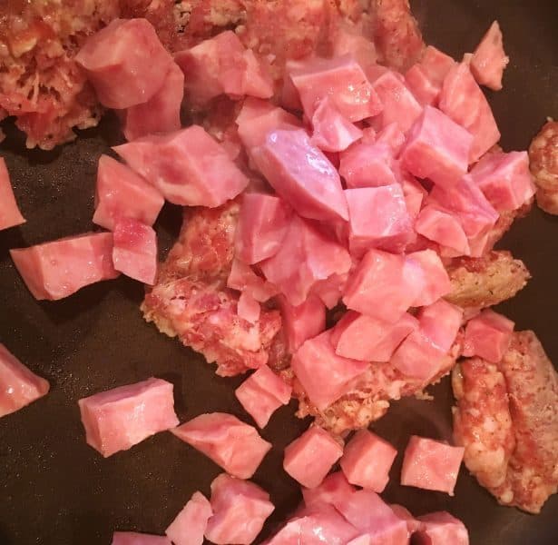 Diced ham and sausage browning in the pan