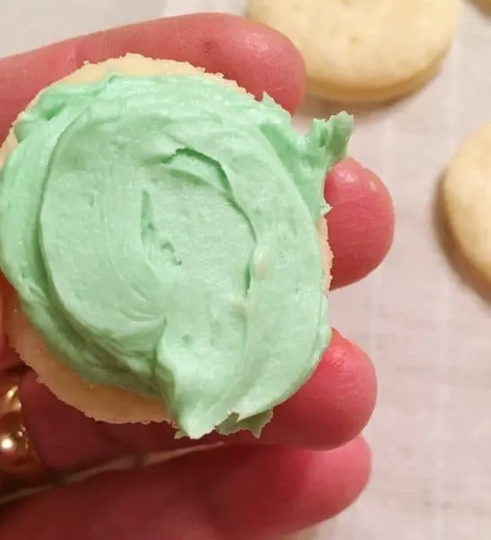 carefully spreading the filling on the cookie