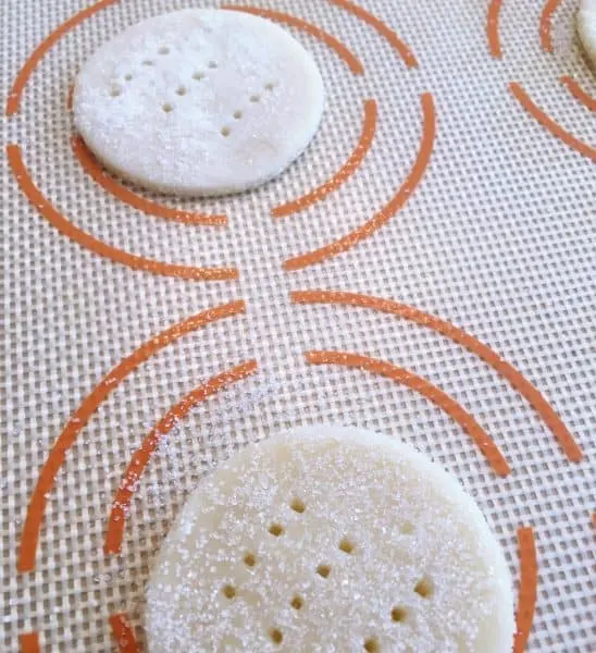 Cookies on silicone mat with fork pricks ready to bake