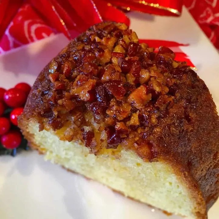 A delicious rum cake slice with nuts on top.