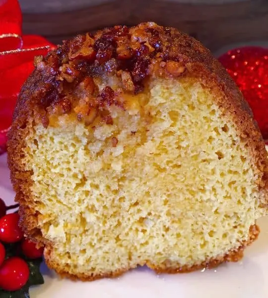 Slice of the Worlds Best Rum Cake topped with delicious pecans