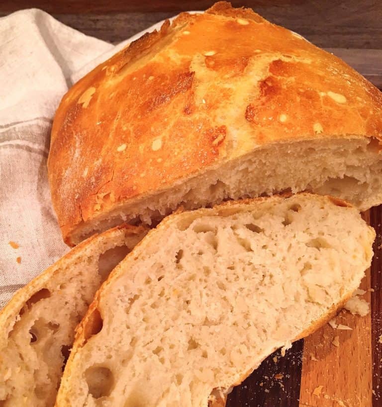 Loaf of Crusty Artisan Bread sliced on a bread board.