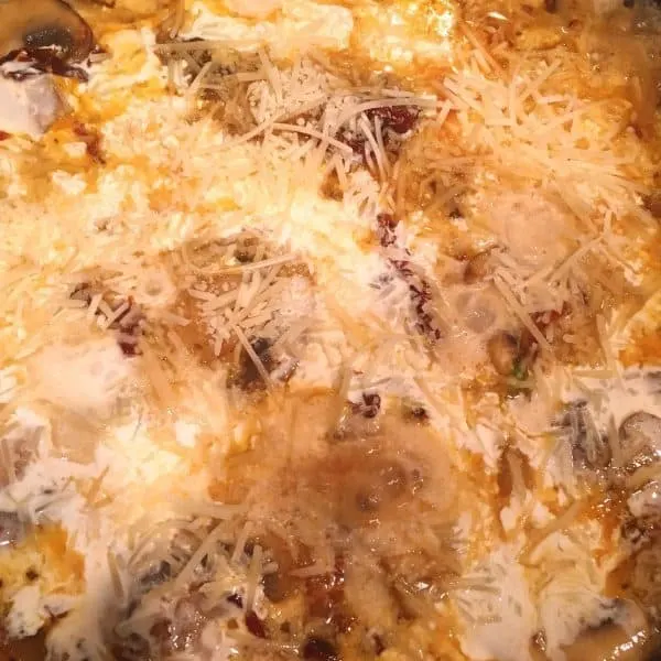 Adding cream, Parmesan cheese, to create the sauce for pasta dish