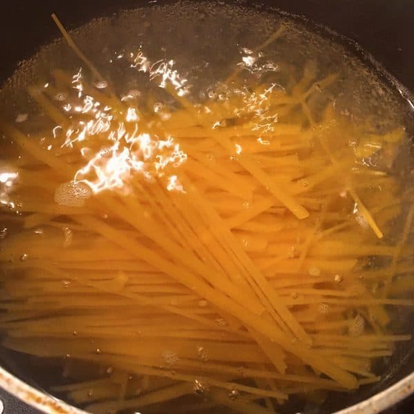 Pot with boiling water and pasta for dish