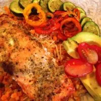 Salmon Bowls in a bowl with baked salmon, veggie rice, and fresh vegetables.