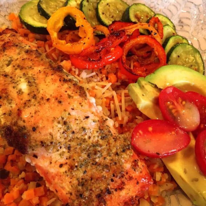 Salmon Bowls in a bowl with baked salmon, veggie rice, and fresh vegetables.