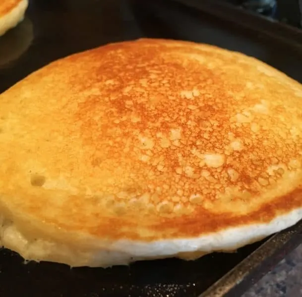 Buttermilk pancake flipped over on griddle