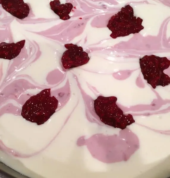 Dollops of Raspberry Sauce on top of cheesecake batter before swirling into cheesecake batter.