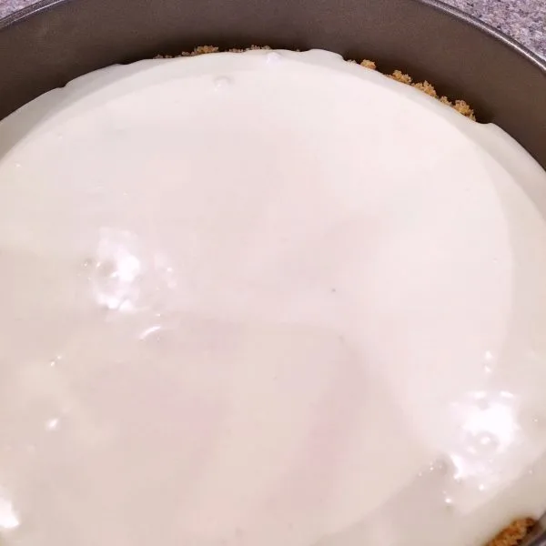 Coconut Cheesecake batter poured into prepared crust in spring form pan for Coconut Raspberry Cheesecake