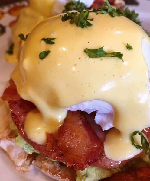 Holandaise sauce poured over Eggs Benedict