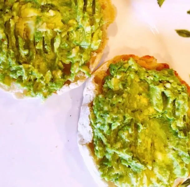 Two slices of English Muffin with smashed avocado