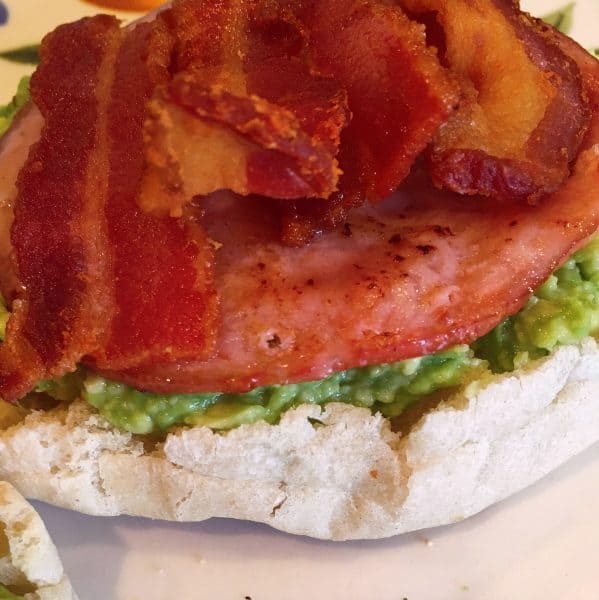 English muffin with avocado spread, canadian bacon and traditional bacon