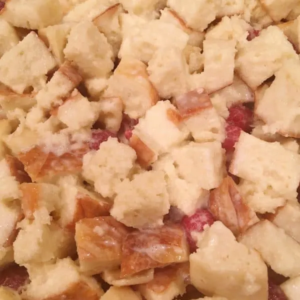 Baking dish with soaked bread cubes and raspberry filling. Topped with remaining bread cubes.