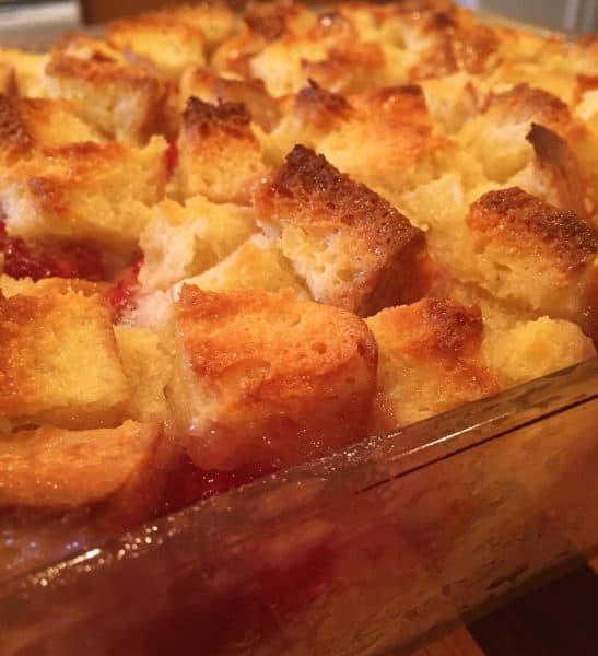 Baked Raspberry Bread Pudding with golden crusty peaks and bubbling raspberry filling
