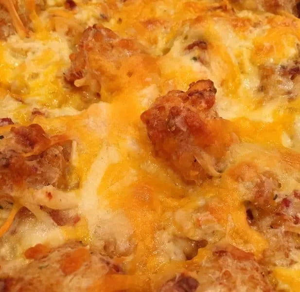 Baked 9 x 13 pan of Chicken Ranch Tater Tot Casserole with melted cheese on top