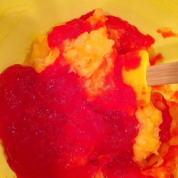 Large bowl with pineapple pudding mixture combining with jello mixture.