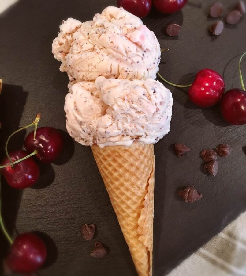Two scoops of Cherry Chocolate Chip Ice cream on a cone