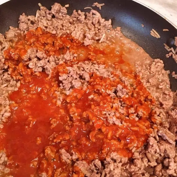 Add enchilada sauce to ground beef