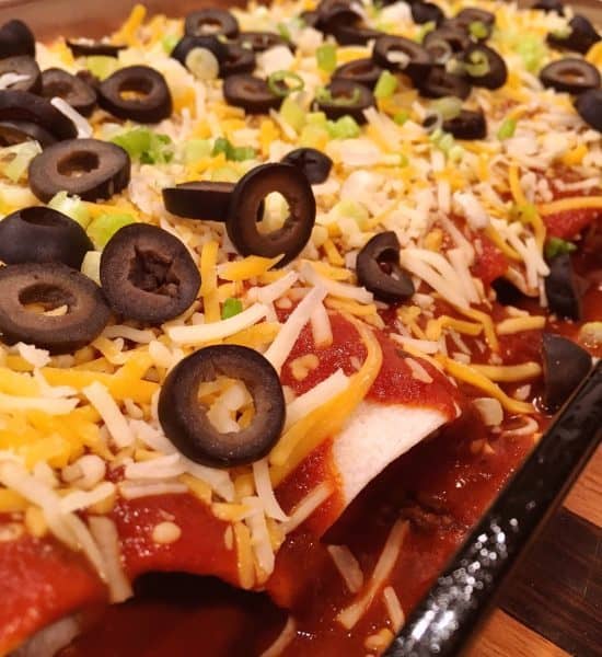 Enchilada's garnished with olives and green onion