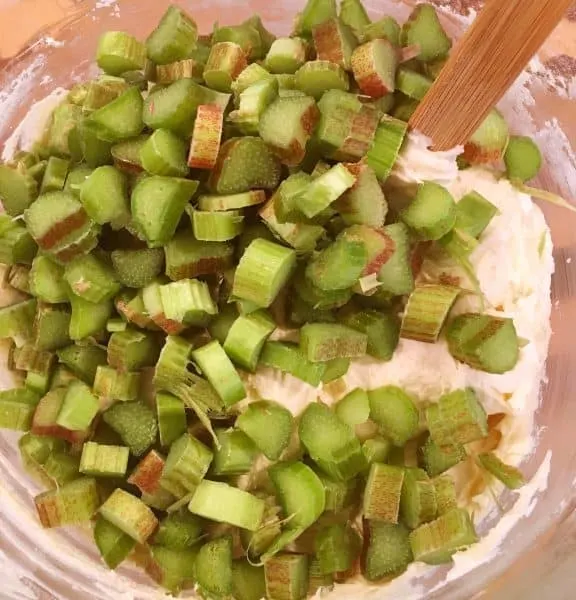 Rhubarb being added to cake batter