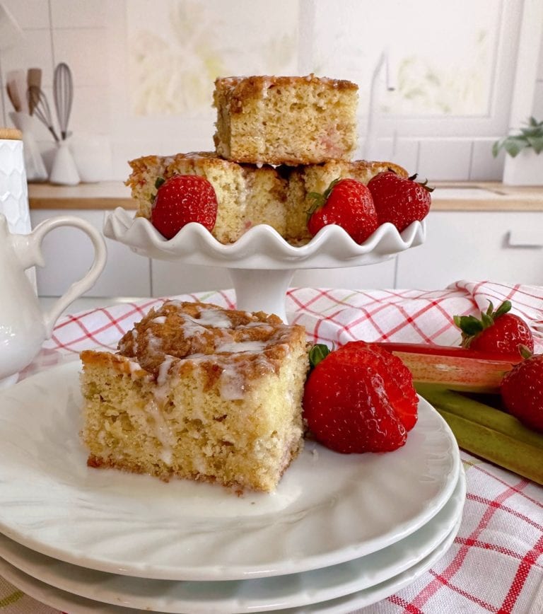 Rhubarb Sour Cream Coffee cake on a serving plate and piled high on a cake plate.