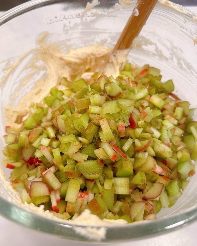 Rhubarb being folded into cake batter.