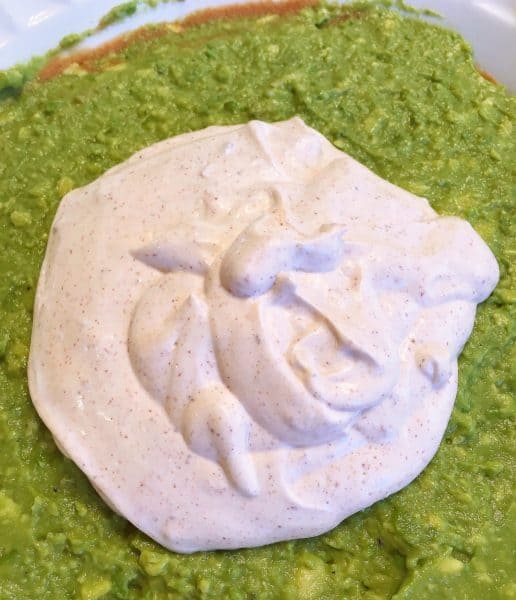 Sour cream taco seasoning mixture on top of guacamole