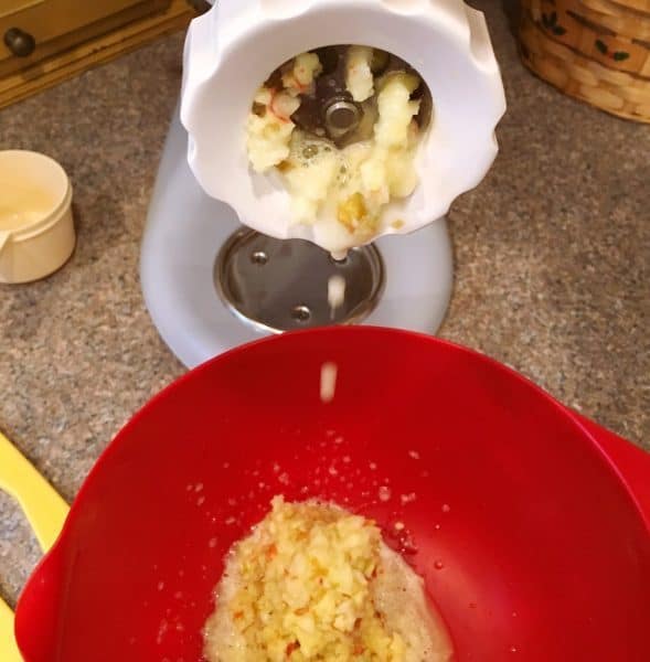 Food grinder grinding up apples