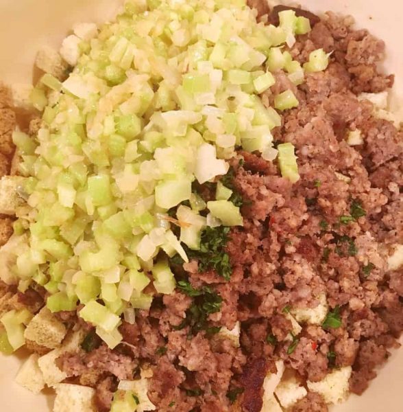 Adding onions and celery to bread cubes