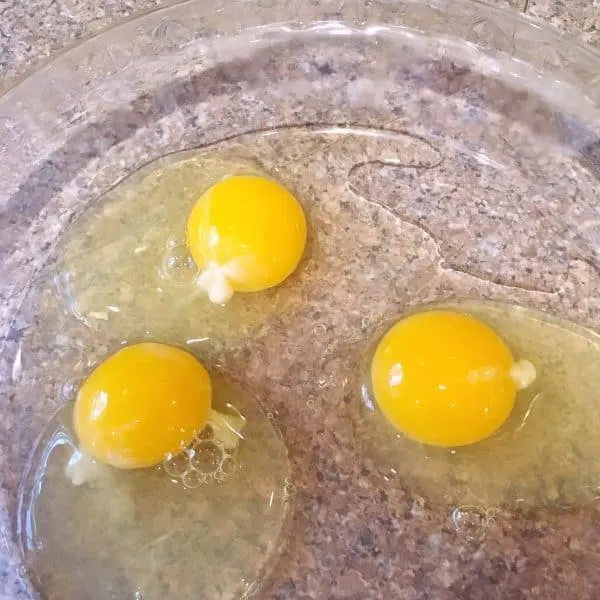 Three whole large eggs in shallow dish