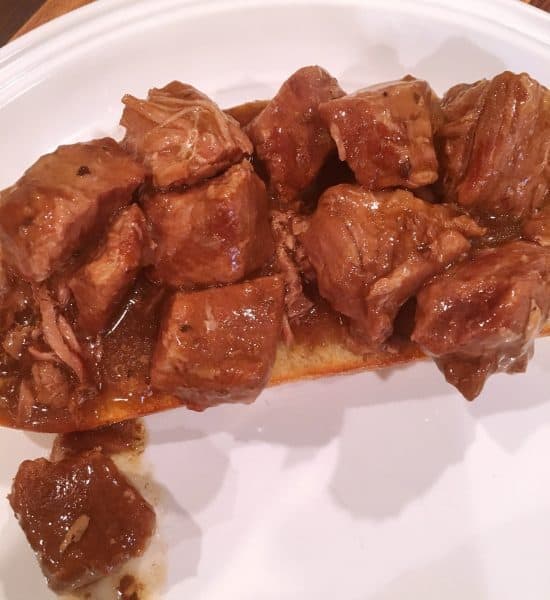 Hot beef and gravy on top of sour dough bread