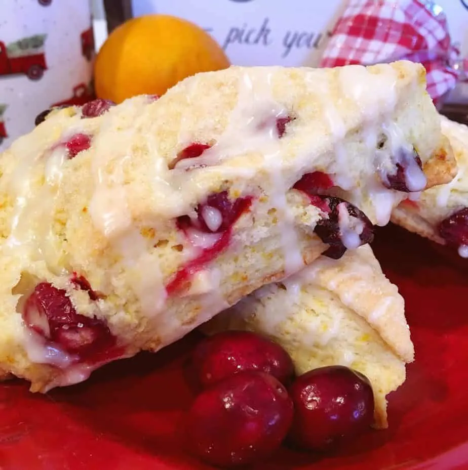 Cranberry Orange Scones stack with fresh cranberries around them.