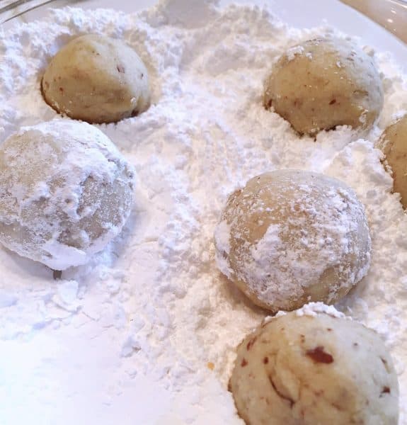 Snowball Cookies being rolled in powder sugar