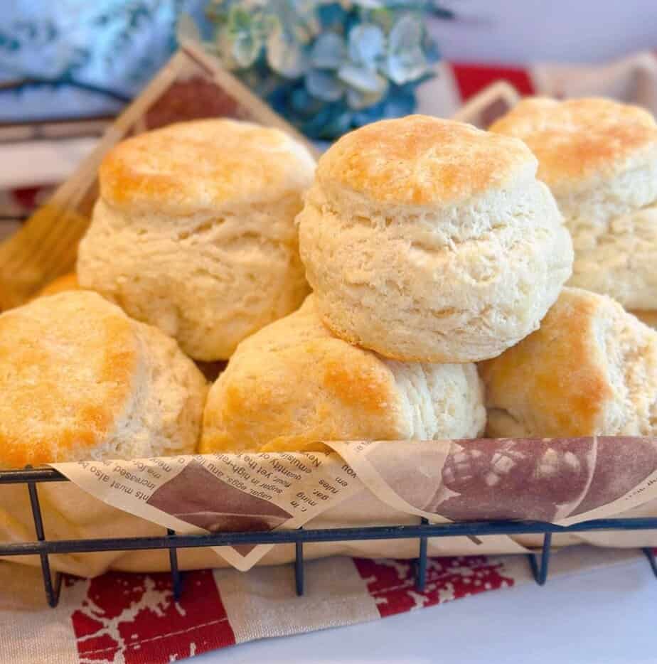 A basket full of buttermilk biscuits piled high.