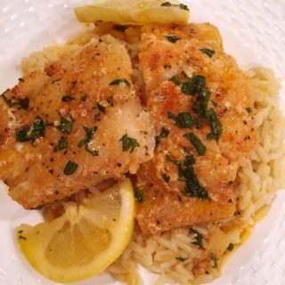 Buttered Cod over Rice Pilaf with lemon slices.