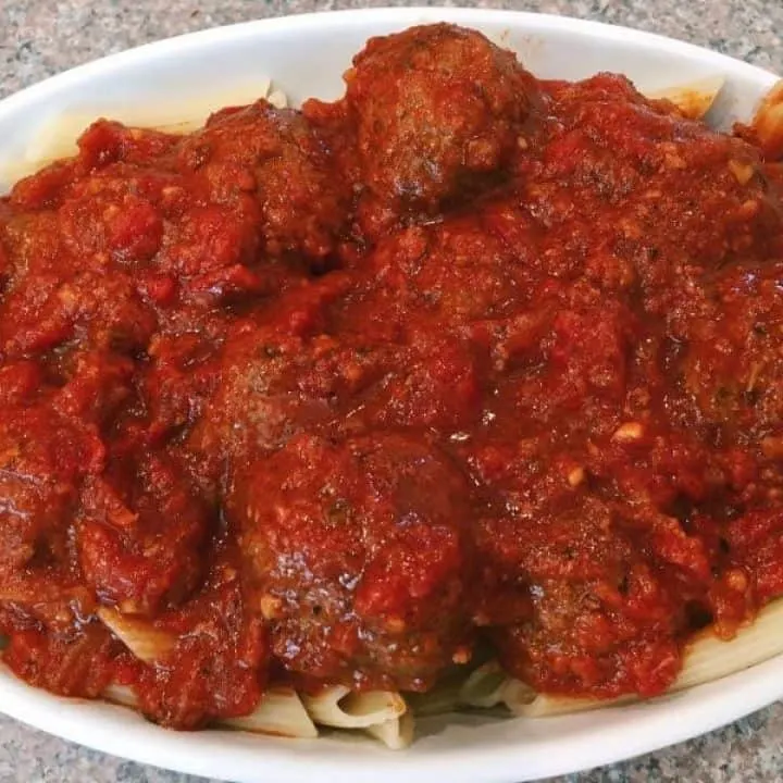 Meatballs and pasta in a baking dish with lots of yummy sauce.